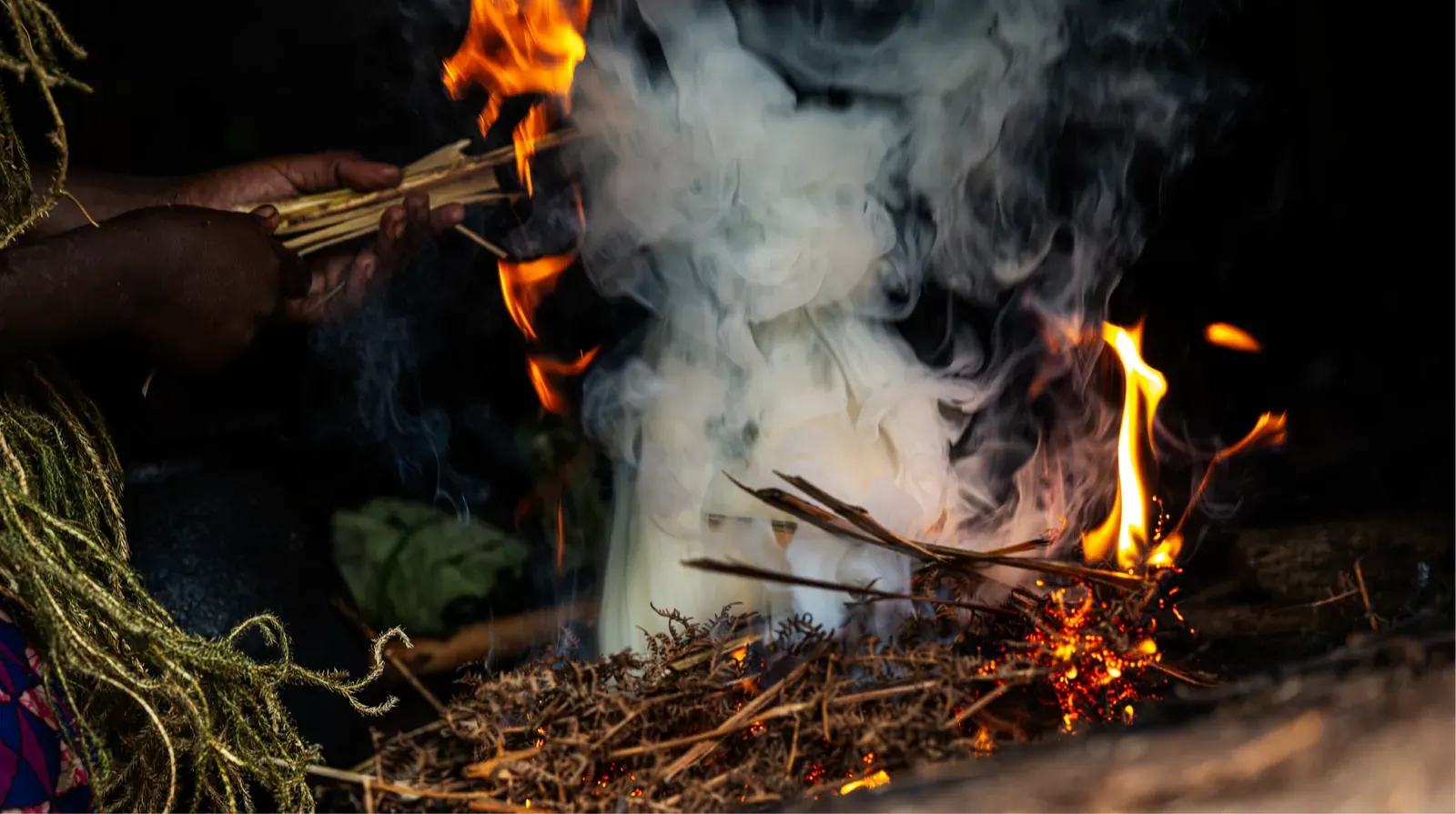 Members of a Batwa community around a fire on the Batwa Trail, south-west Uganda